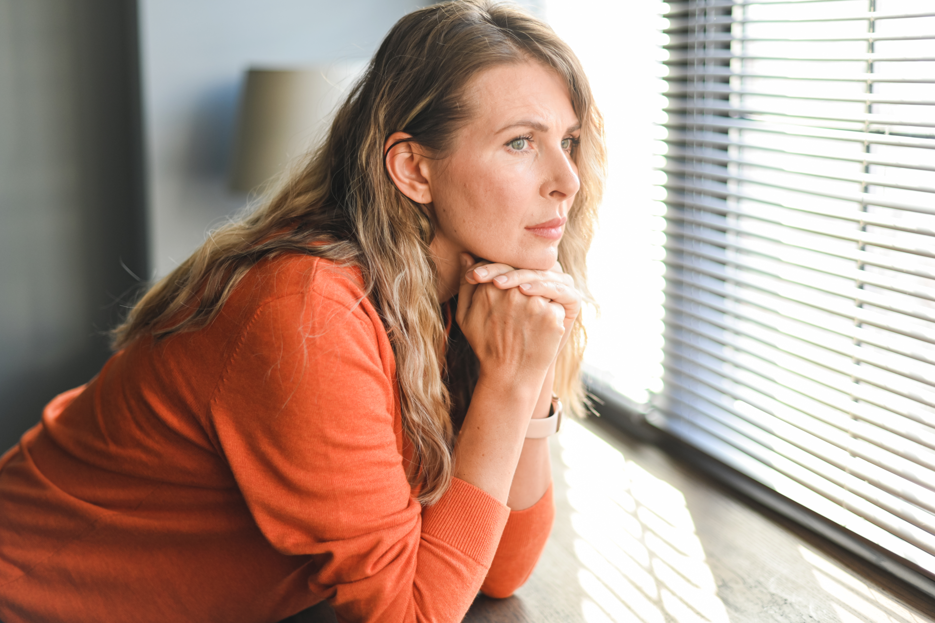 frau_steht_am_fenster_und_schaut_nach_draussen